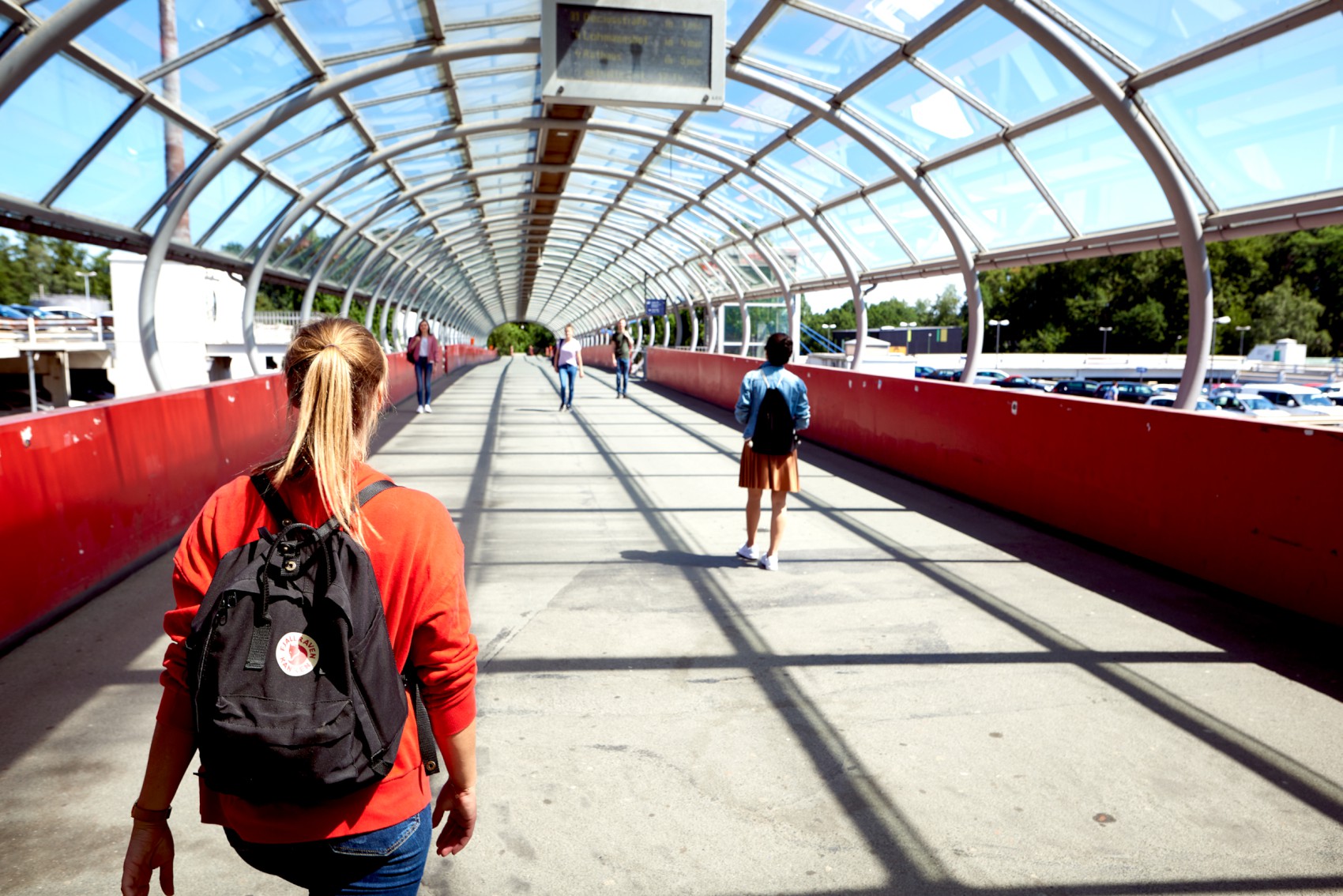 Studentinnen gehen über die Straßenbahnbrücke an der Uni
