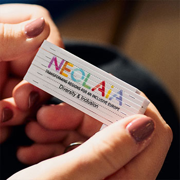 Finger halten Zollstock mit der Aufschrift "NEOLAiA - Diversity and Inclusion"