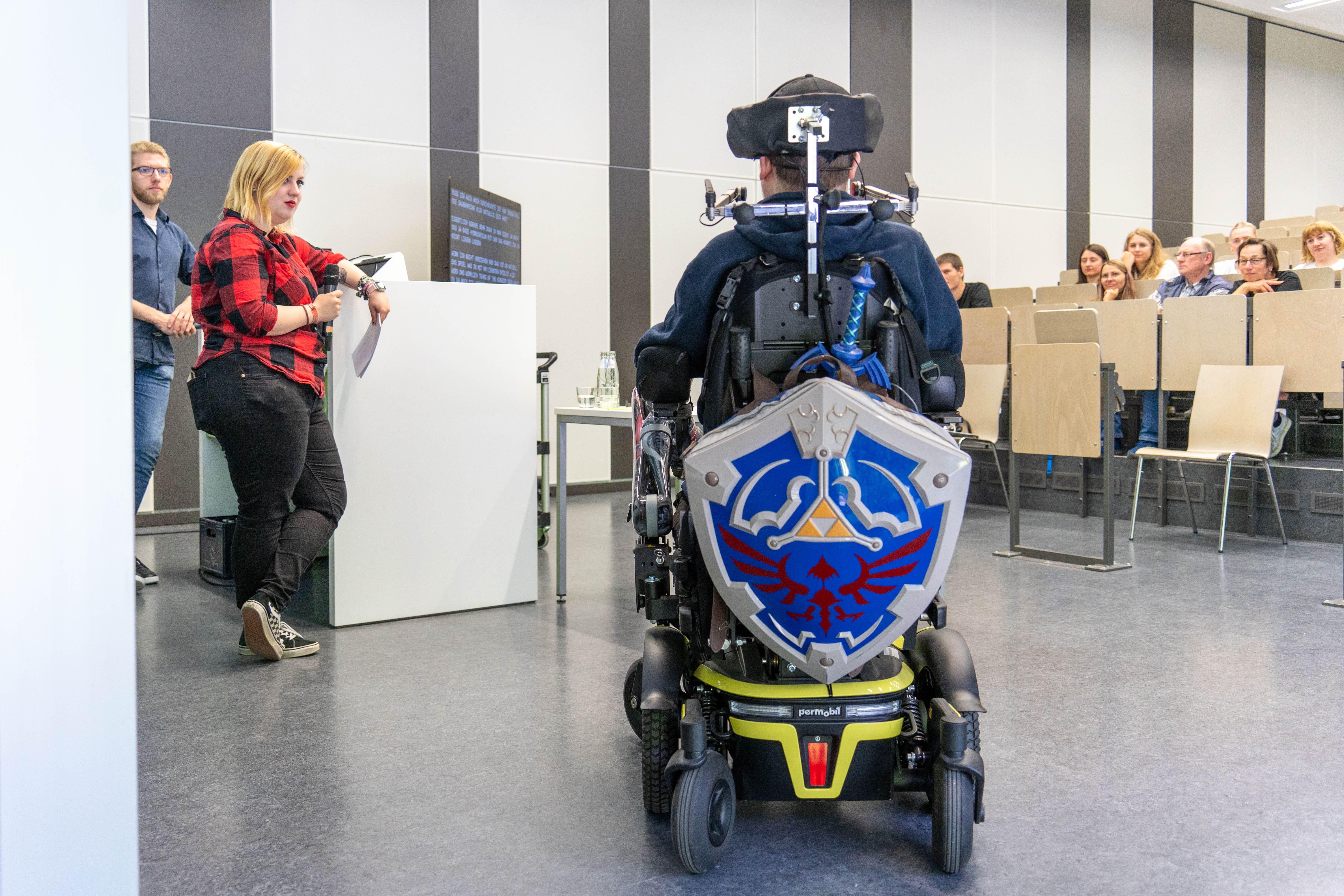 Rückseite des Rollstuhls von Dennis Winkens mit angebrachtem Schild und Schwert aus einem Spiel