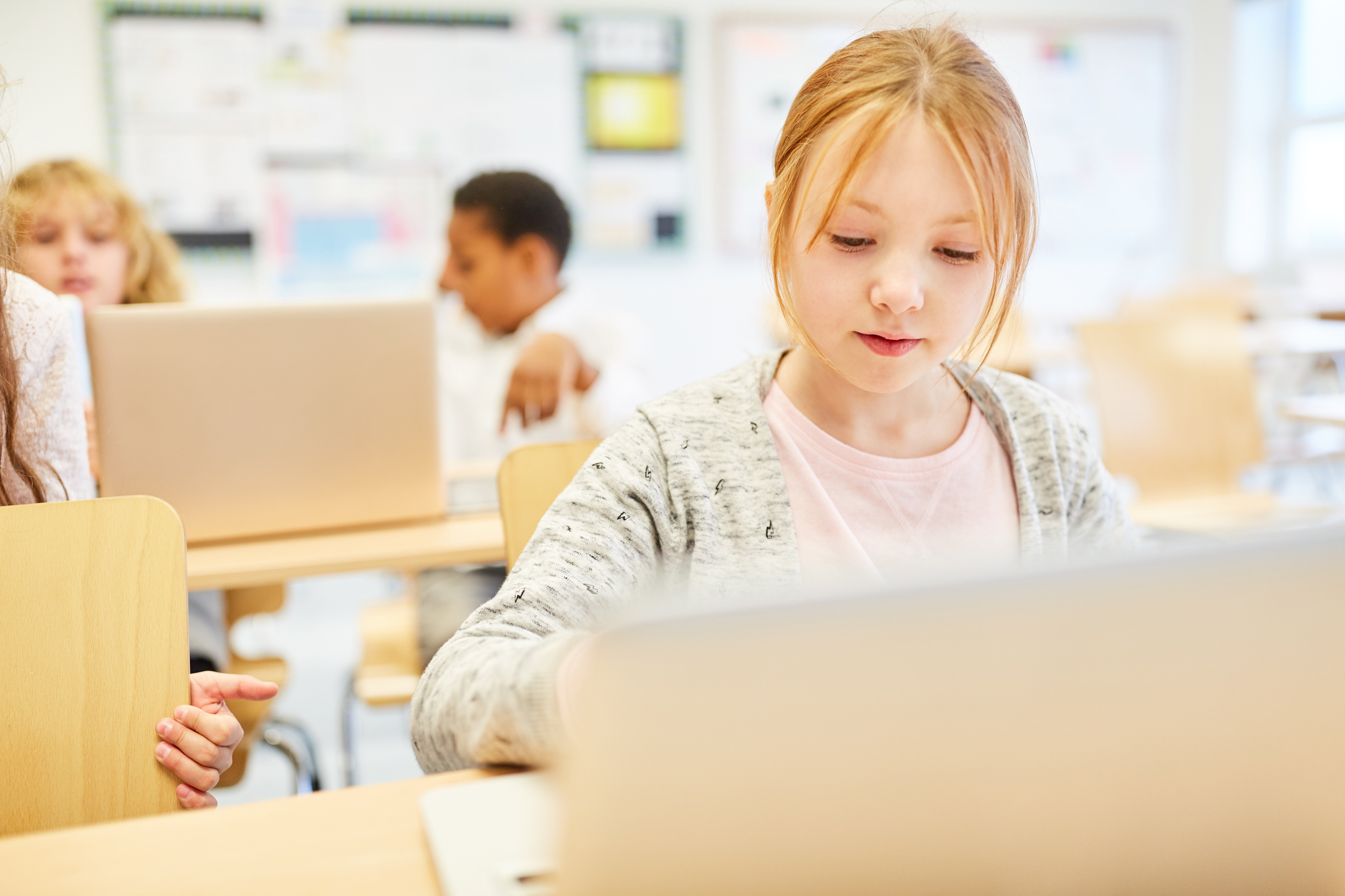 Mdchen konzentriert sich im Informatikunterricht auf seinenLaptop.