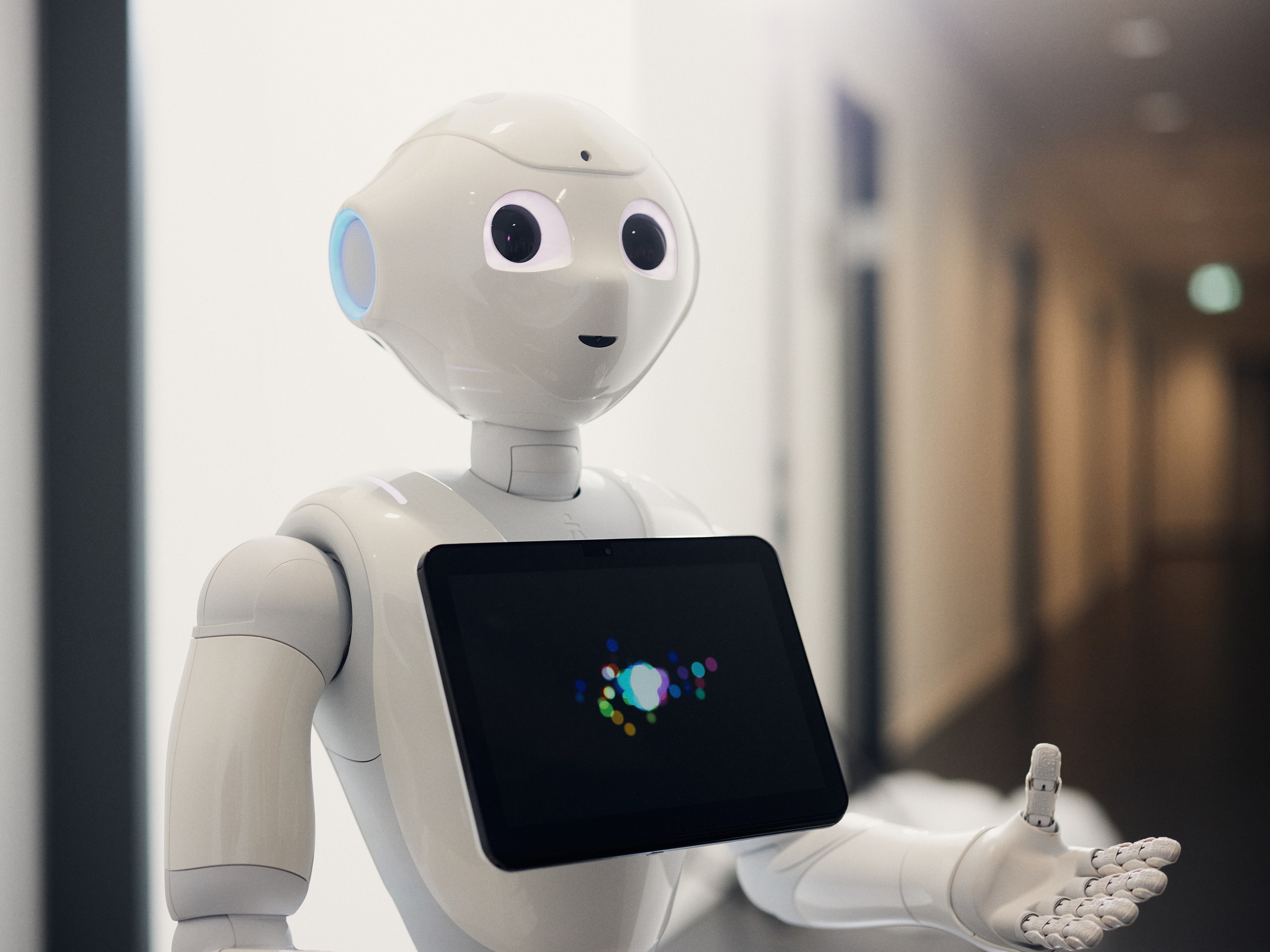 Woman stands in front of virtual robot head Flobi