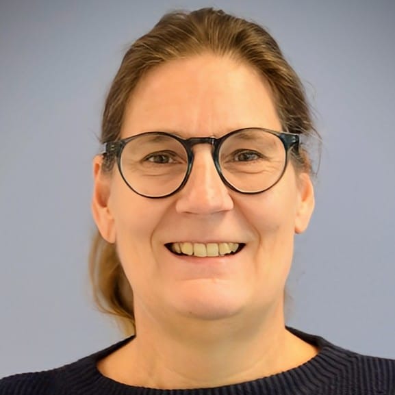Foto von Prof. Dr. Nina Heinrichs vor einer blauen Wand