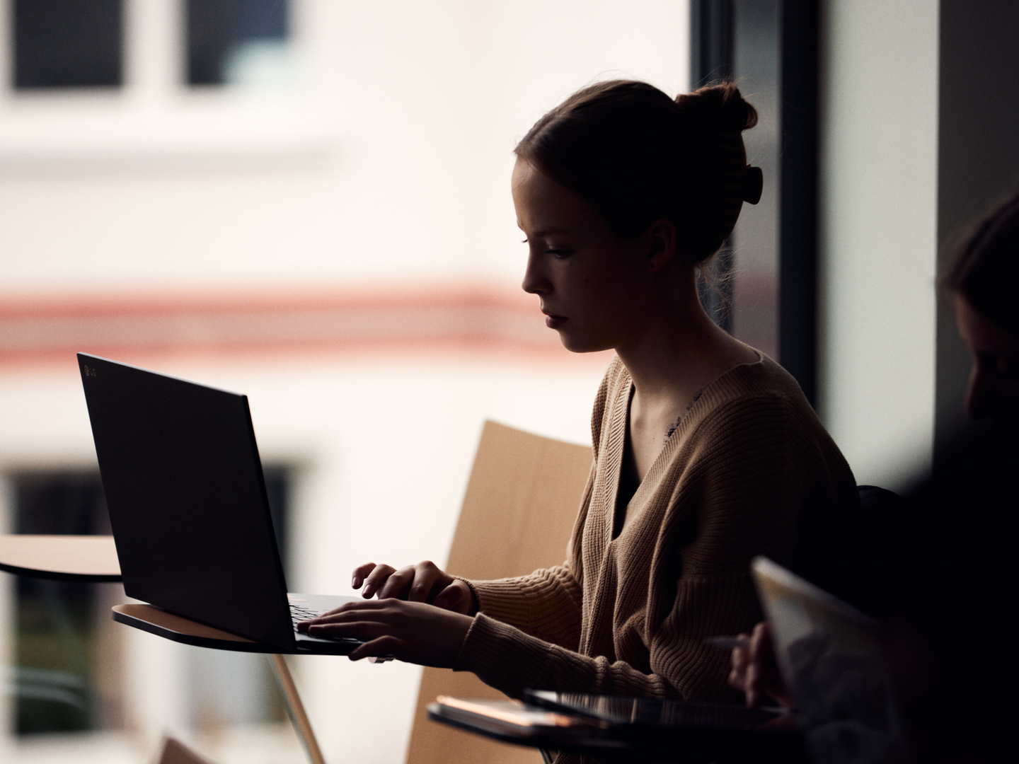 Auf dem Bild ist eine Studierende am Laptop zu sehen.
