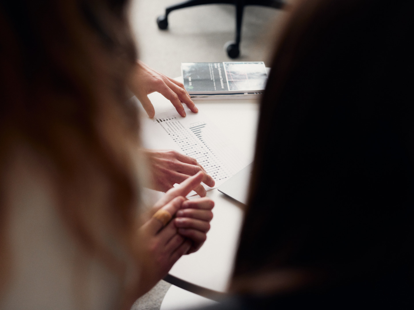 Three persons looking at a sheet of paper