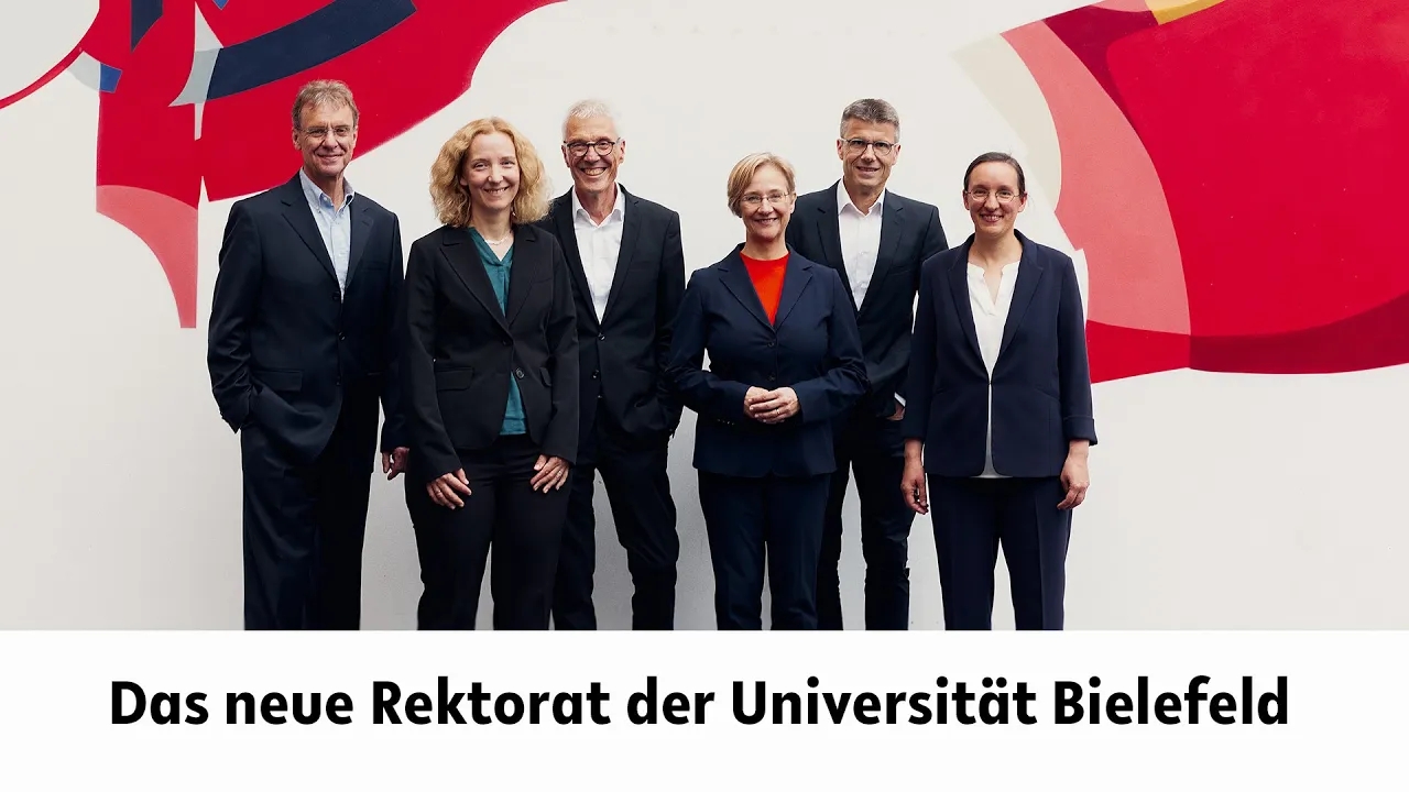 The members of the Rectorate stand in front of the graffiti wall in the central university hall. The caption reads: The new rectorate of Bielefeld University.