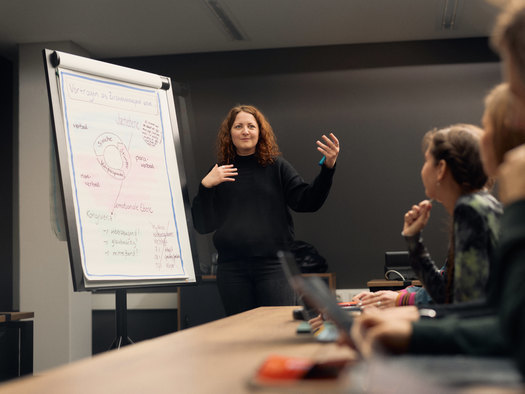 Frau hält Vortrag an Flipchart