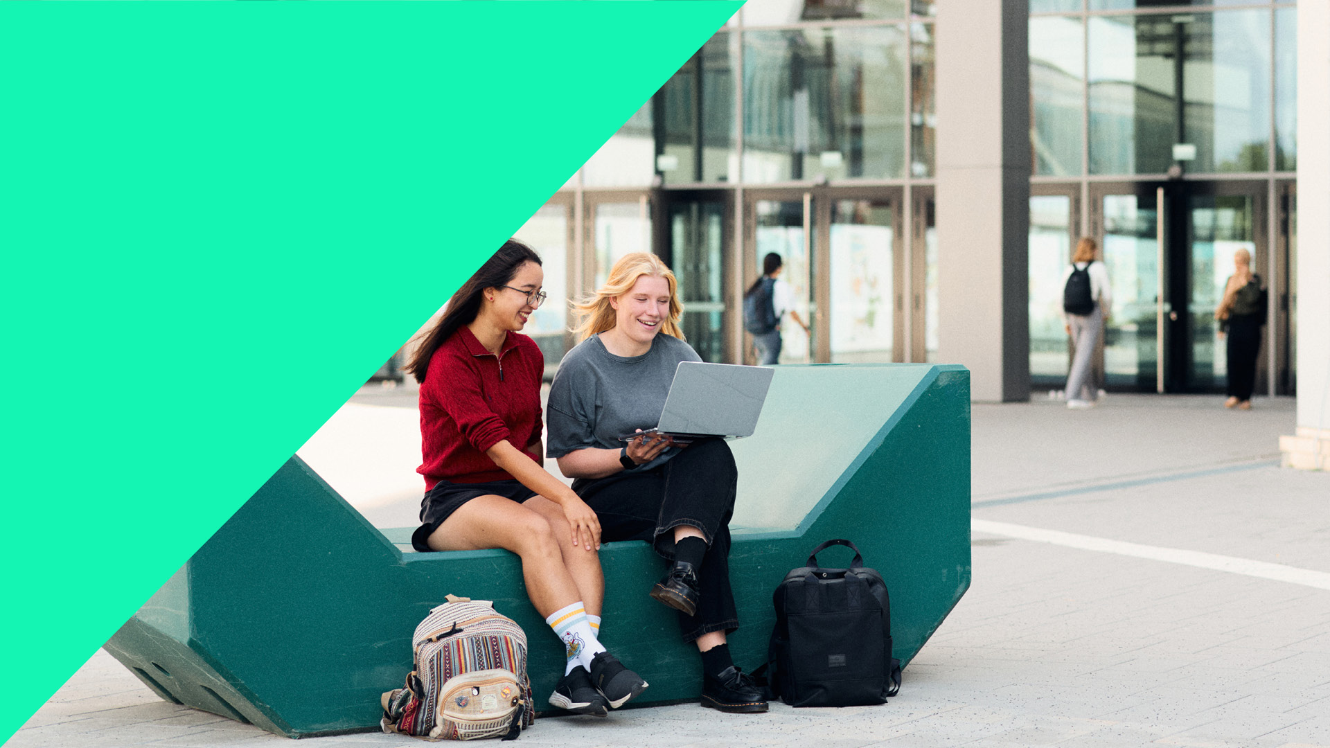 Studierende sitzen vor der Uni Bielefeld