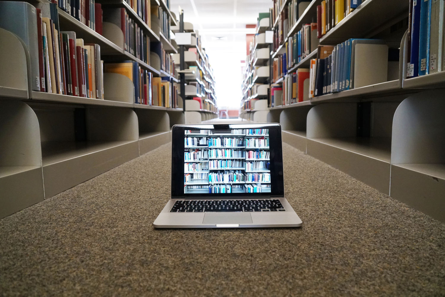 Laptop zwischen Bücherregalen