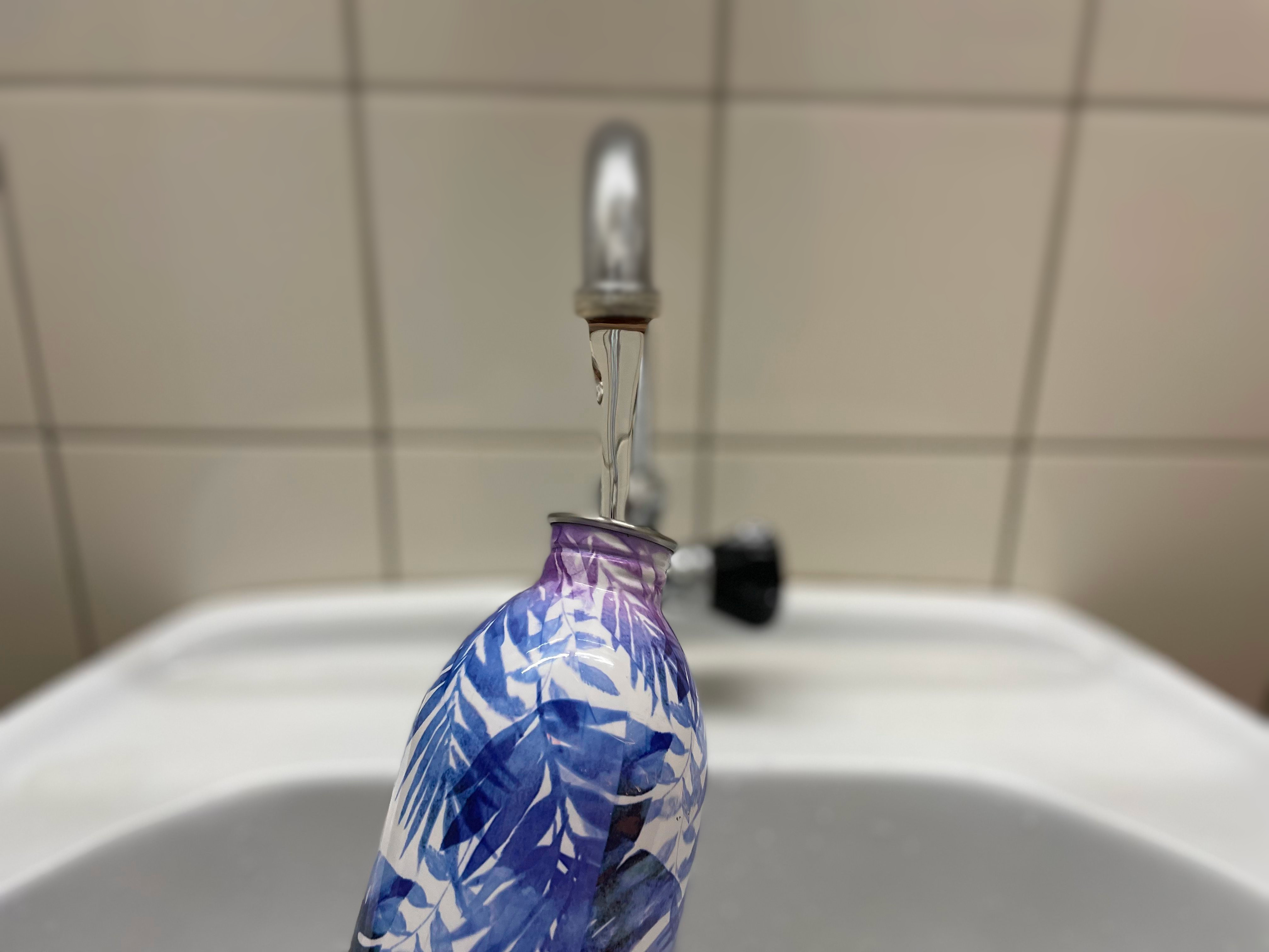 Drinking bottle is filled with tap water