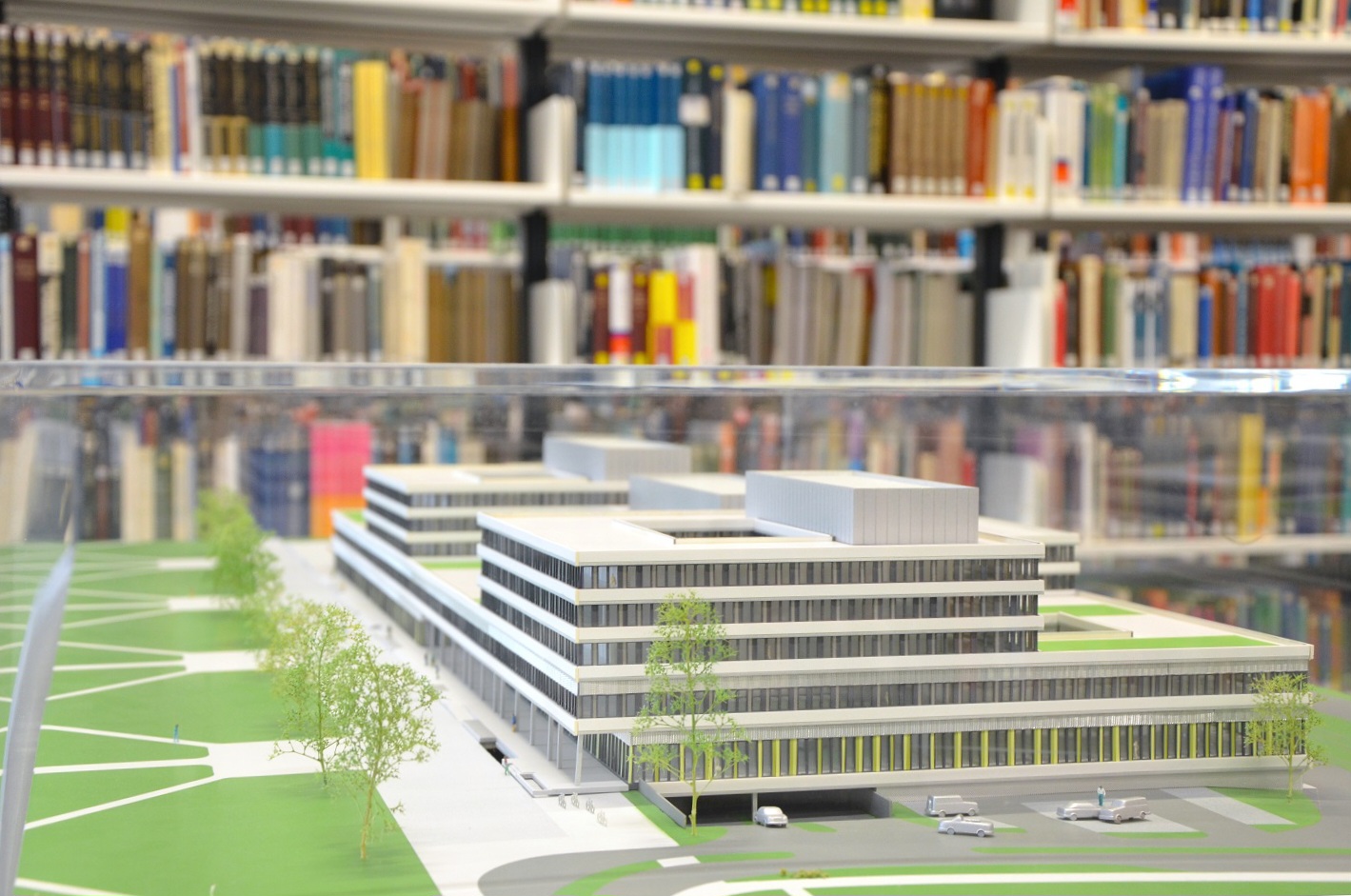 Miniaturmodell Gebäude X vor einem Bücherregal