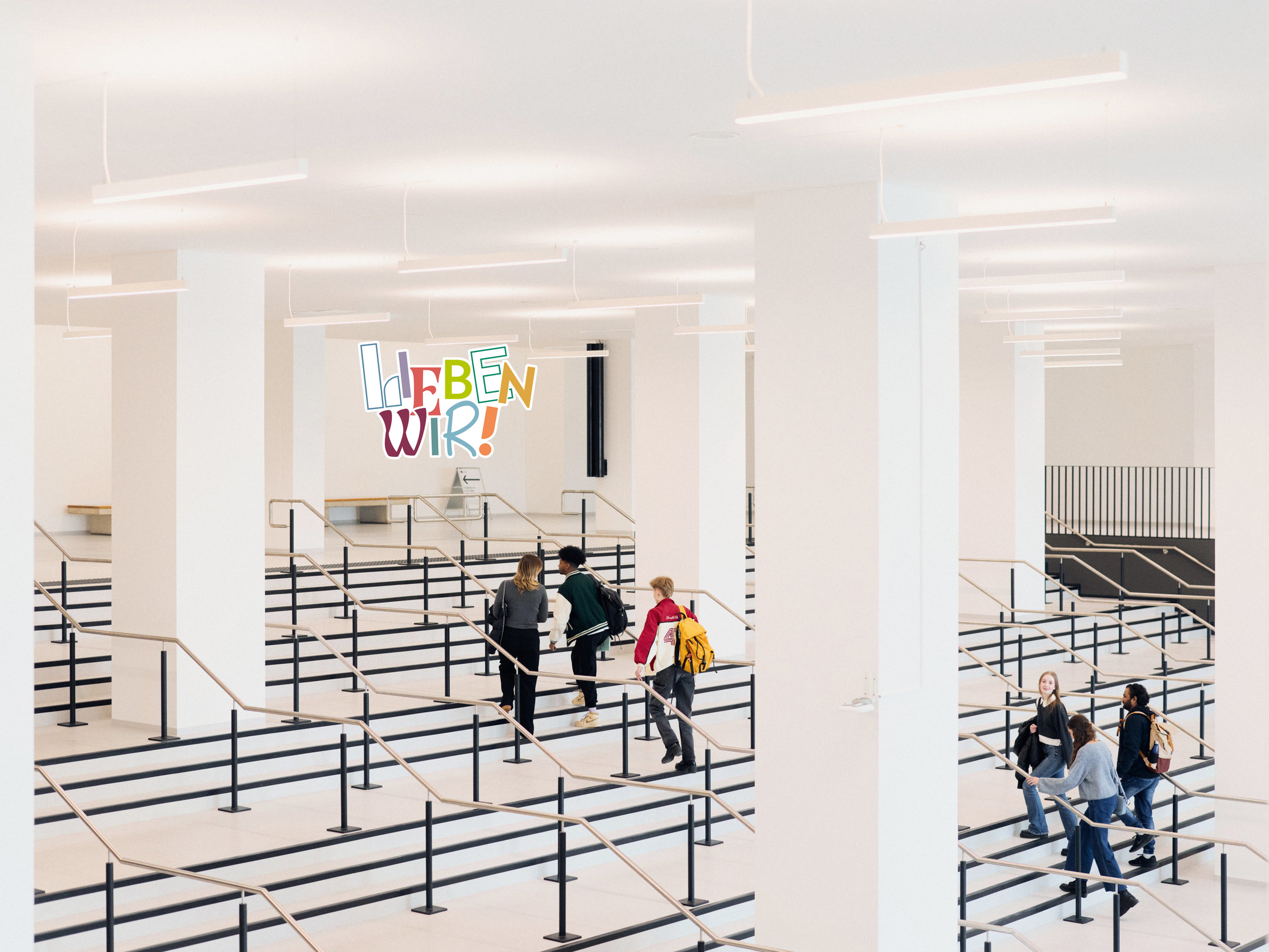 Studierende gehen die große Treppe hoch - Bid mit Störer "Lieben Wir" eingefügt