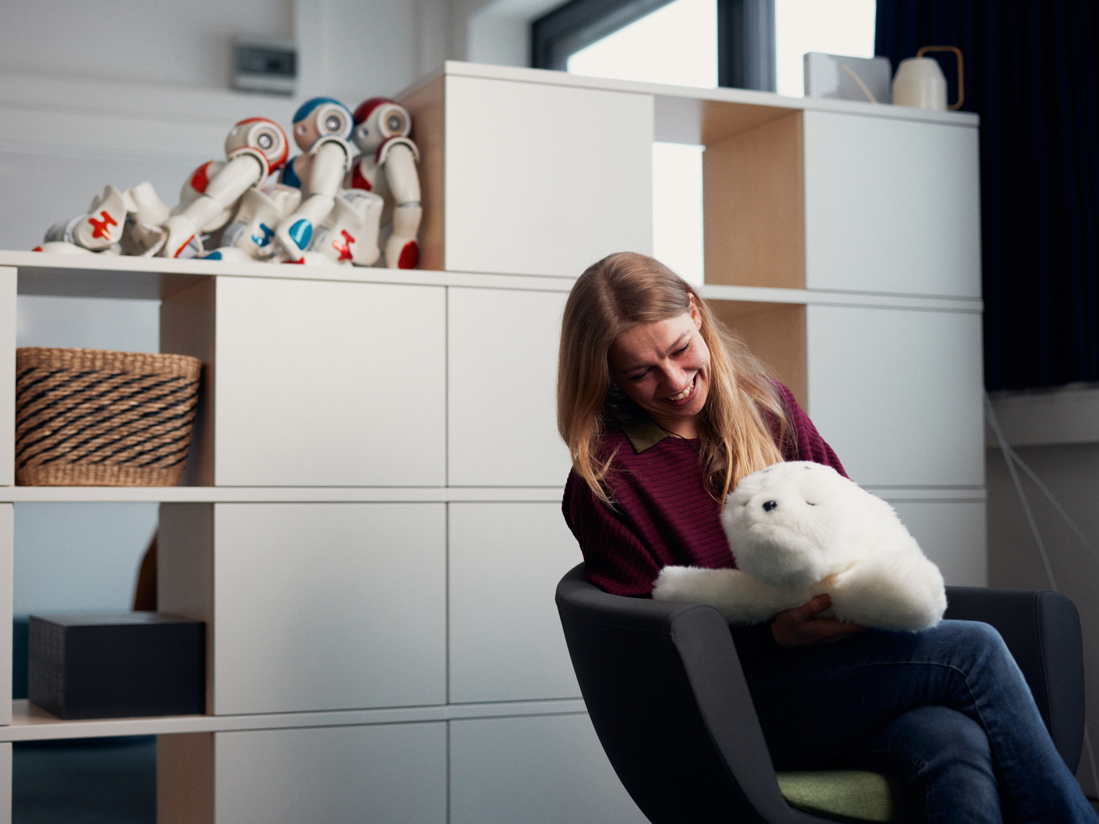 Woman stands in front of virtual robot head Flobi