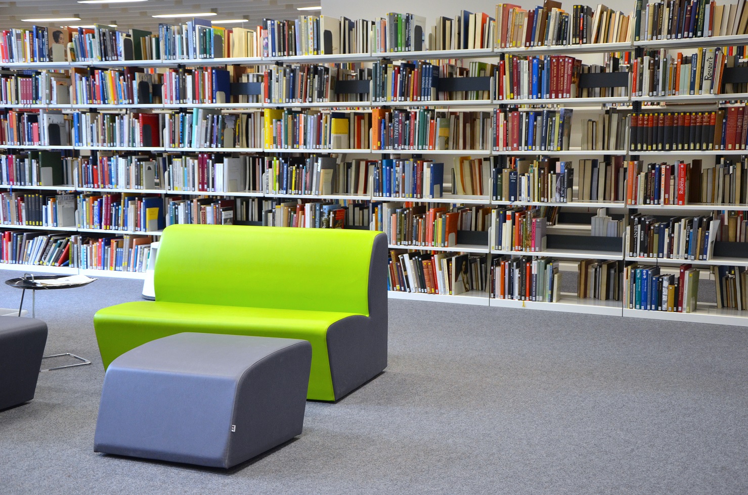 Sofa mit Hocker vor Bücherregalen
