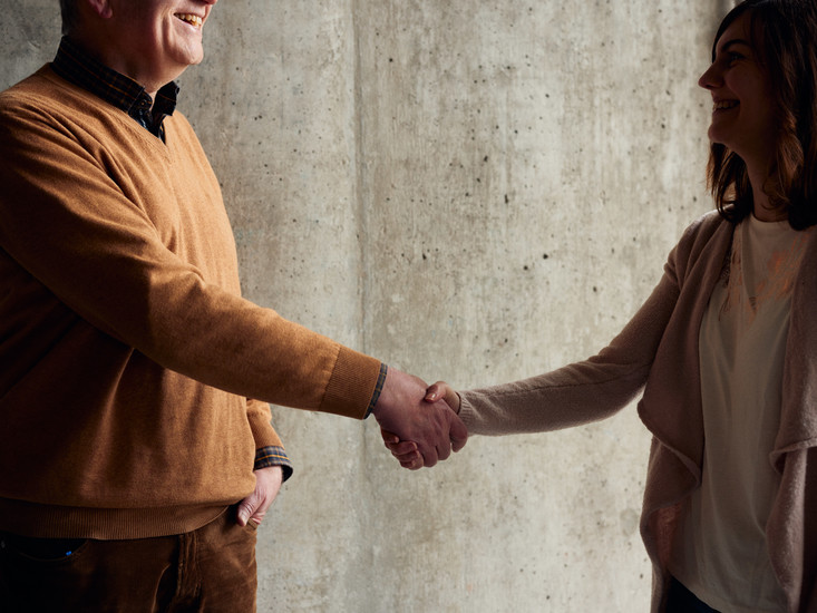 two staff, people shake hands