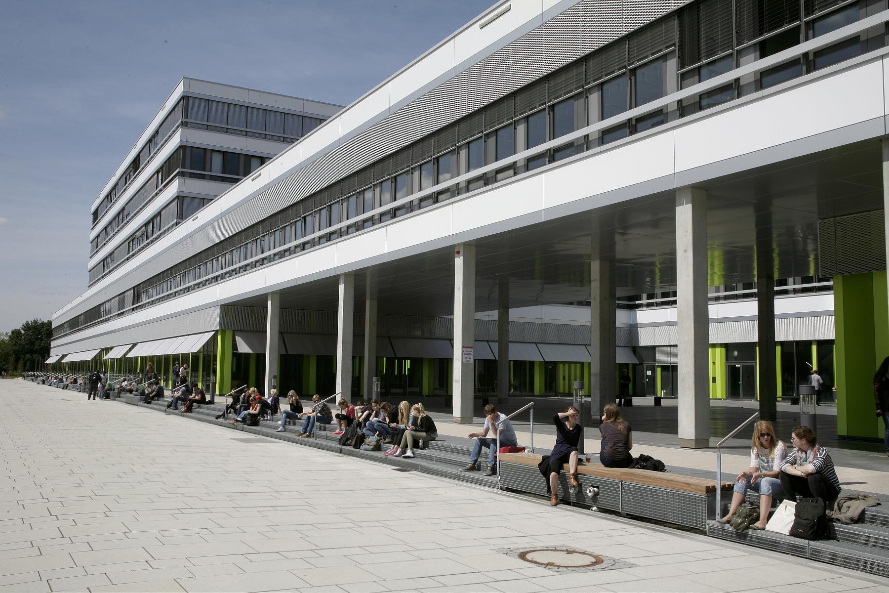 X Gebäude mit Menschen, die davor sitzen