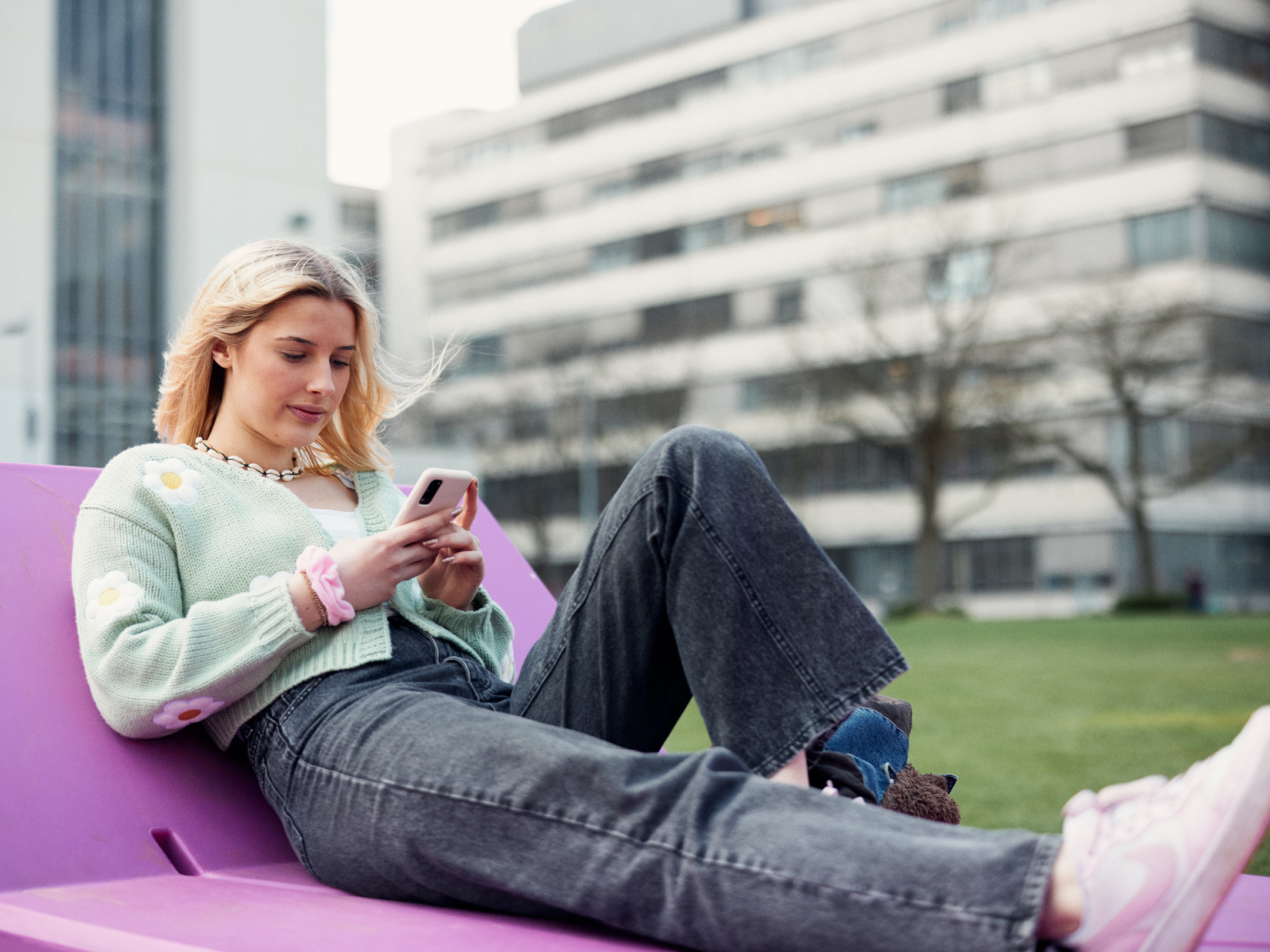 eine Frau sitzt vor dem Hauptgebäude der Universität Bielefeld