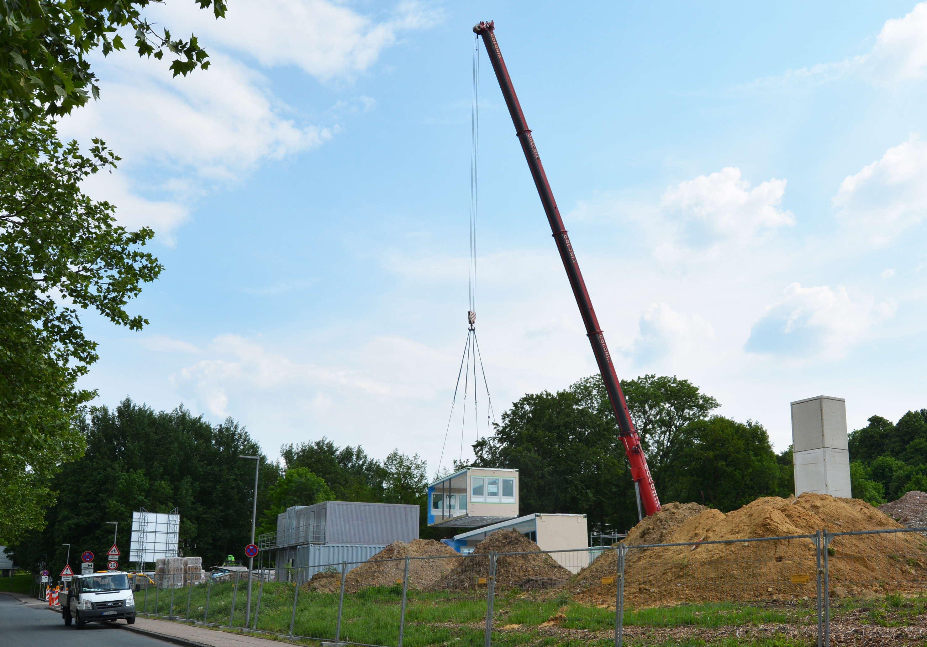 A Crane holds a modul at the site