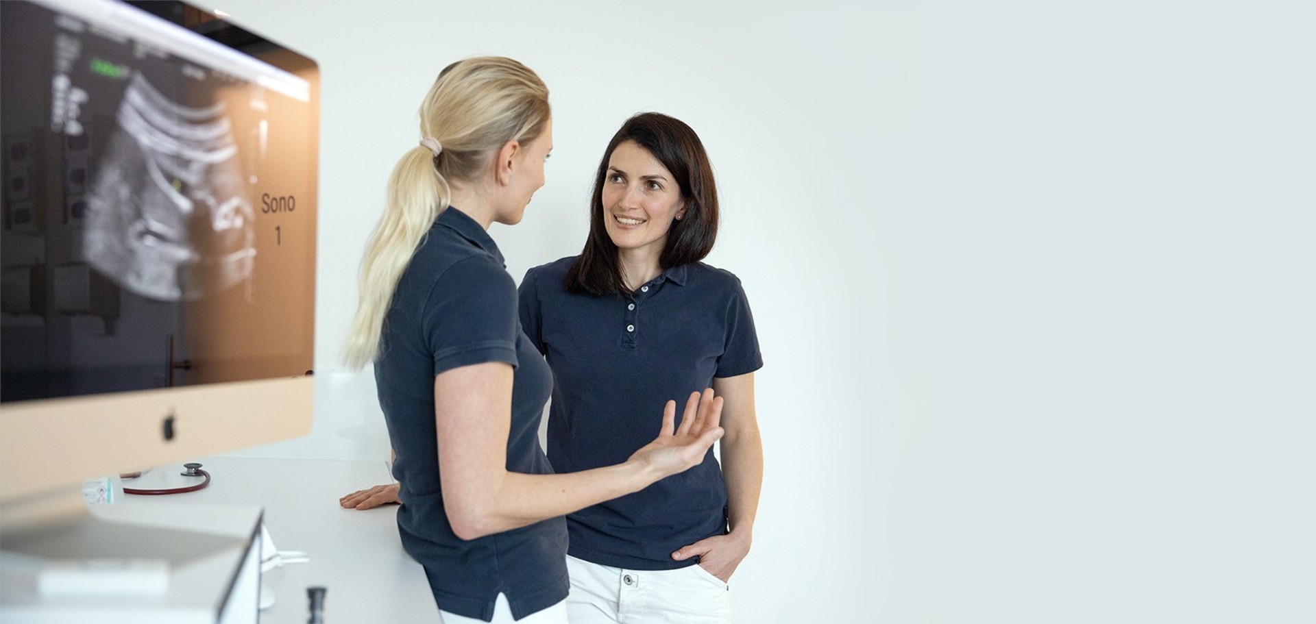 Medizinisches Modell eines Torso, neben dem eine Person in OP-Kleidung steht. Die Person hält das aus dem Modell entnommene Herz in der Hand.