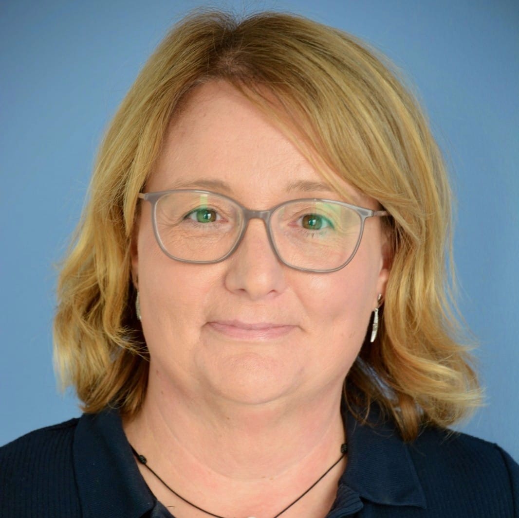 Foto von Melitta Marienburger vor einer blauen Wand