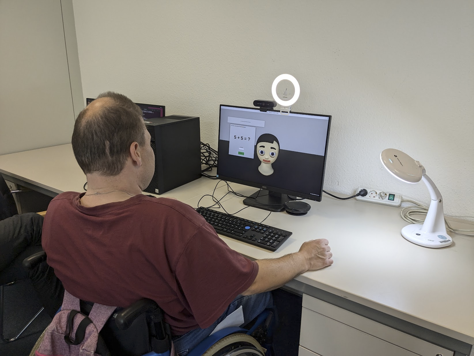 Mensch im Rollstuhl interagiert mit Flobi Simulation