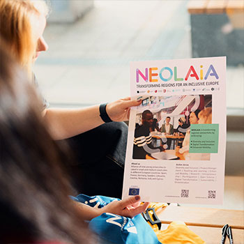 Frau hält ein Poster mit der Aufschrift "NEOLAiA"