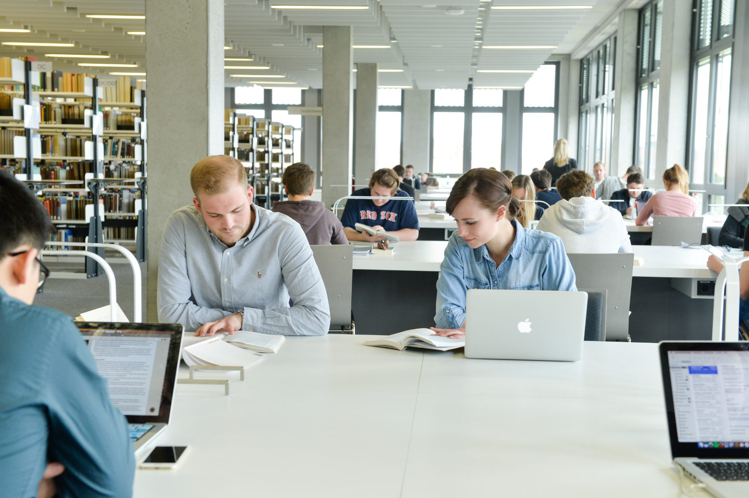Foto einer Person am Laptop in der Bibliothek