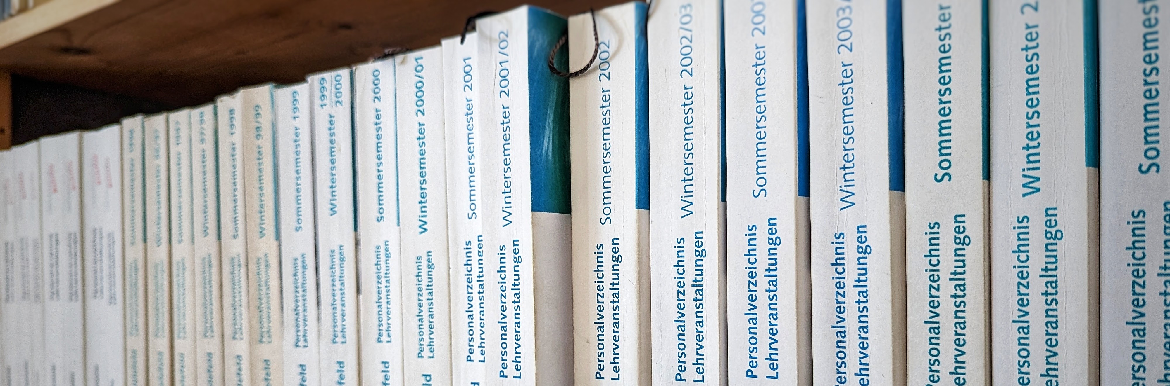 Handy mit geöffneter BIS-App liegt auf einem alten Vorlesungsverzeichnis