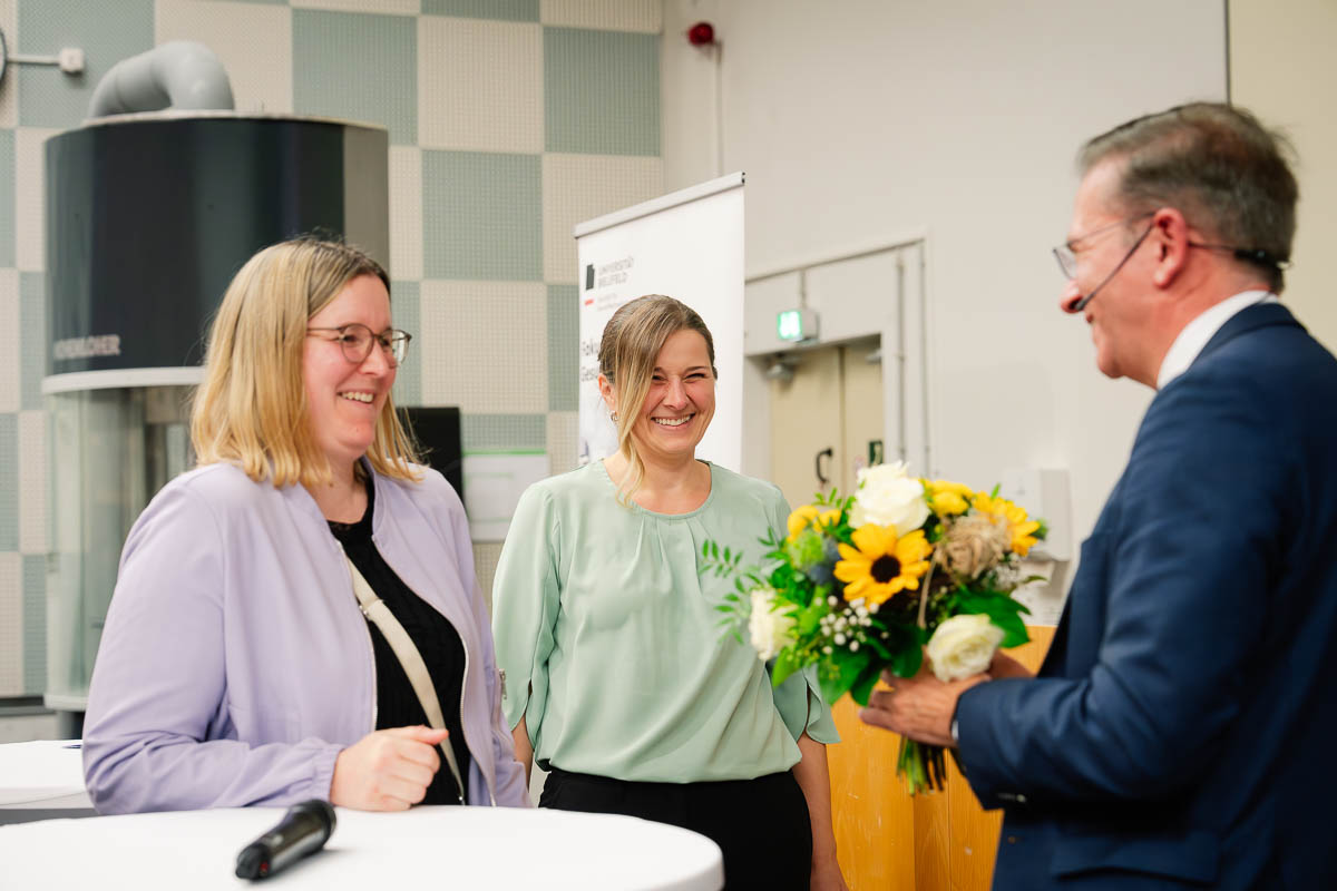 Absolvent*innentag 2025 - Dekan Prof. Dr. Wolfgang Greiner dankt den Mitarbeiter*innen des Prüfungsamtes Olga Rempel und Sabrina Plaß