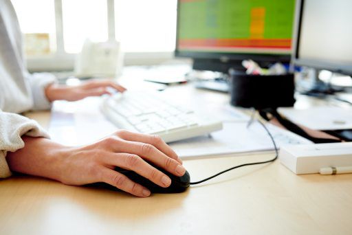 Hand holding mouse on computer