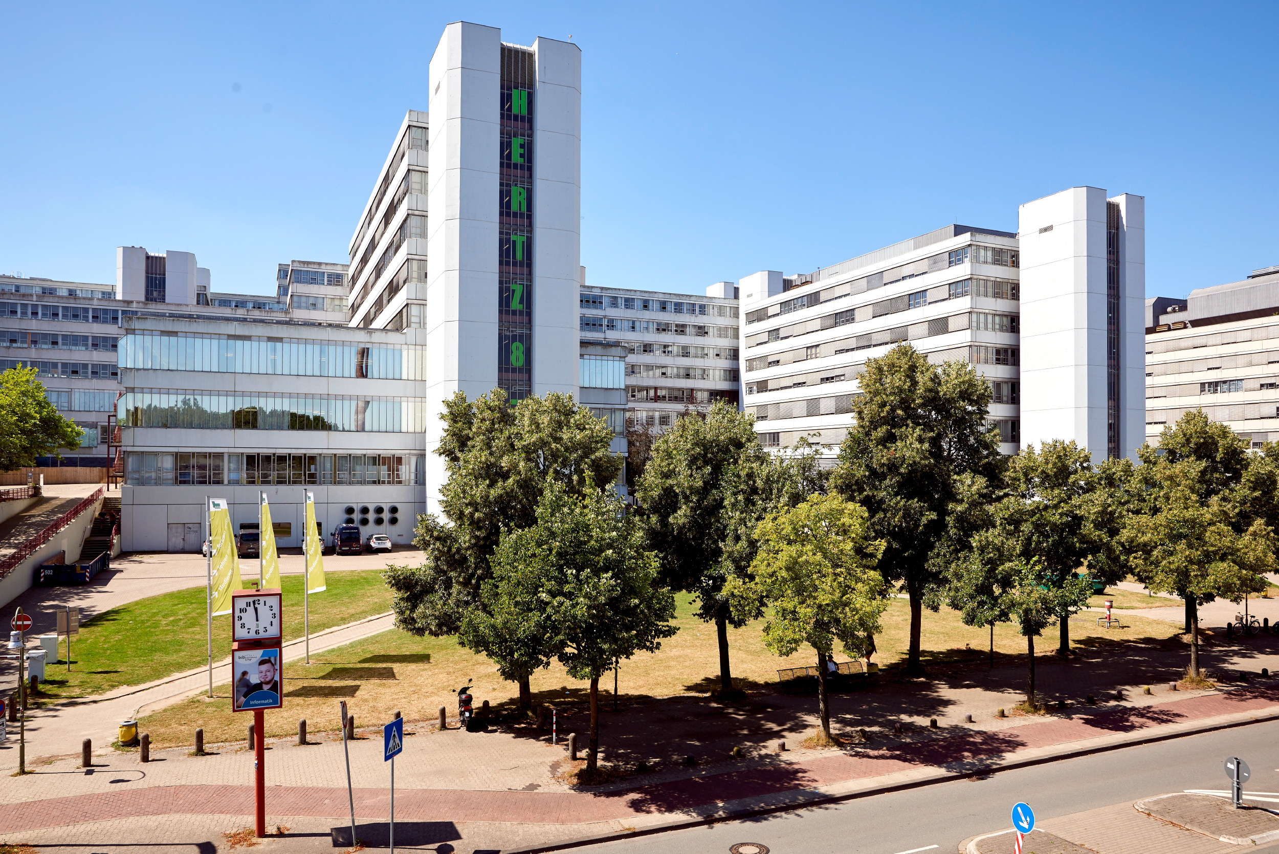 The main university building of Bielefeld University behind trees.