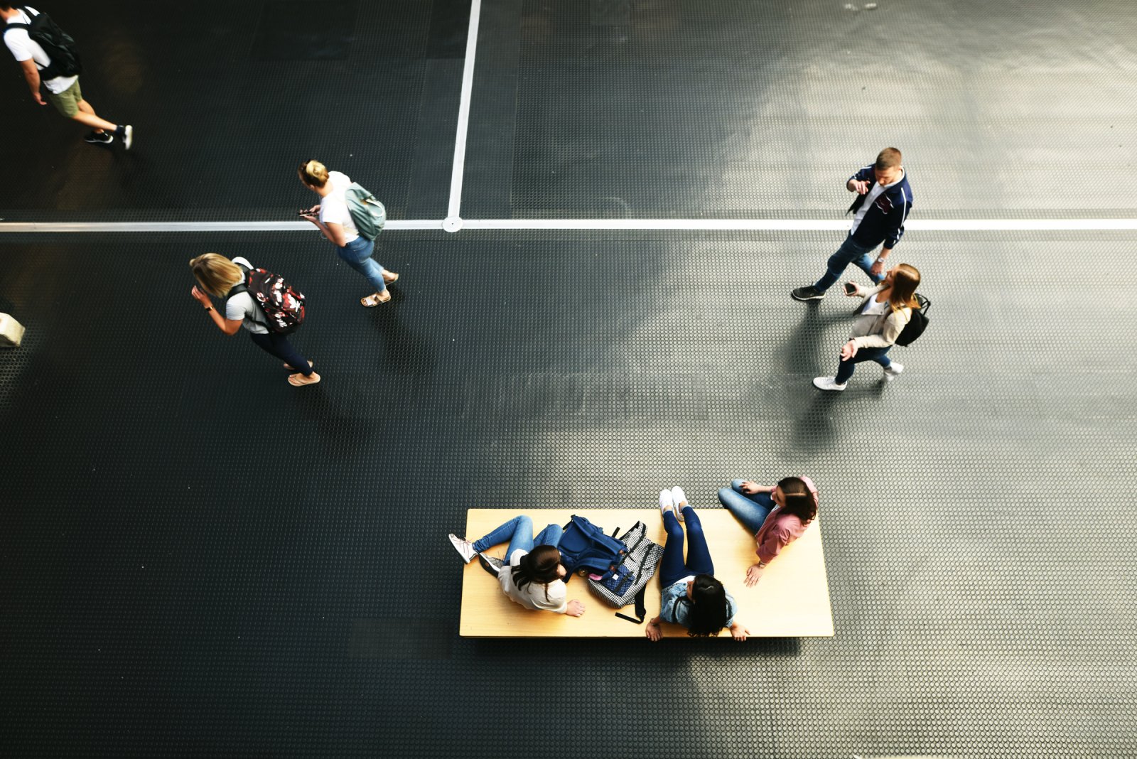 In the hall of Bielefeld University, photographed from above, students walking and sitting