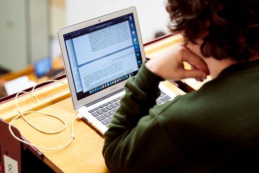 Blick über die Schulter eines Studenten auf einen Laptop-Bildschirm. 