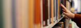 Foto einer Person am Laptop in der Bibliothek
