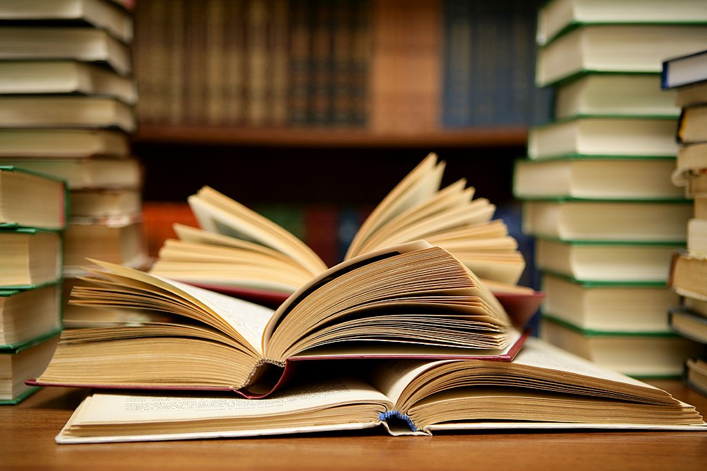 Kachel mit Link zur Publikationsliste des CIAS. Auf dem Kachelbild sind aufgeschlagene Bücher in der Mitte zweier Bücherstapel zu sehen.
