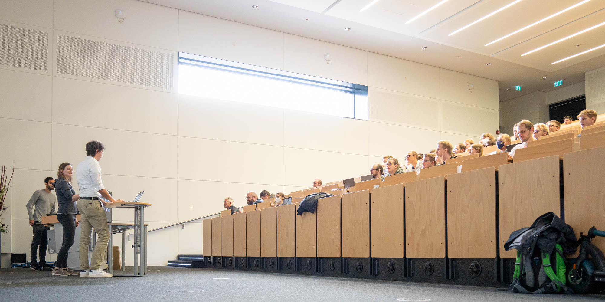 Teaching staff, instructors, lectures in Lecture Hall with live captioning on large monitor