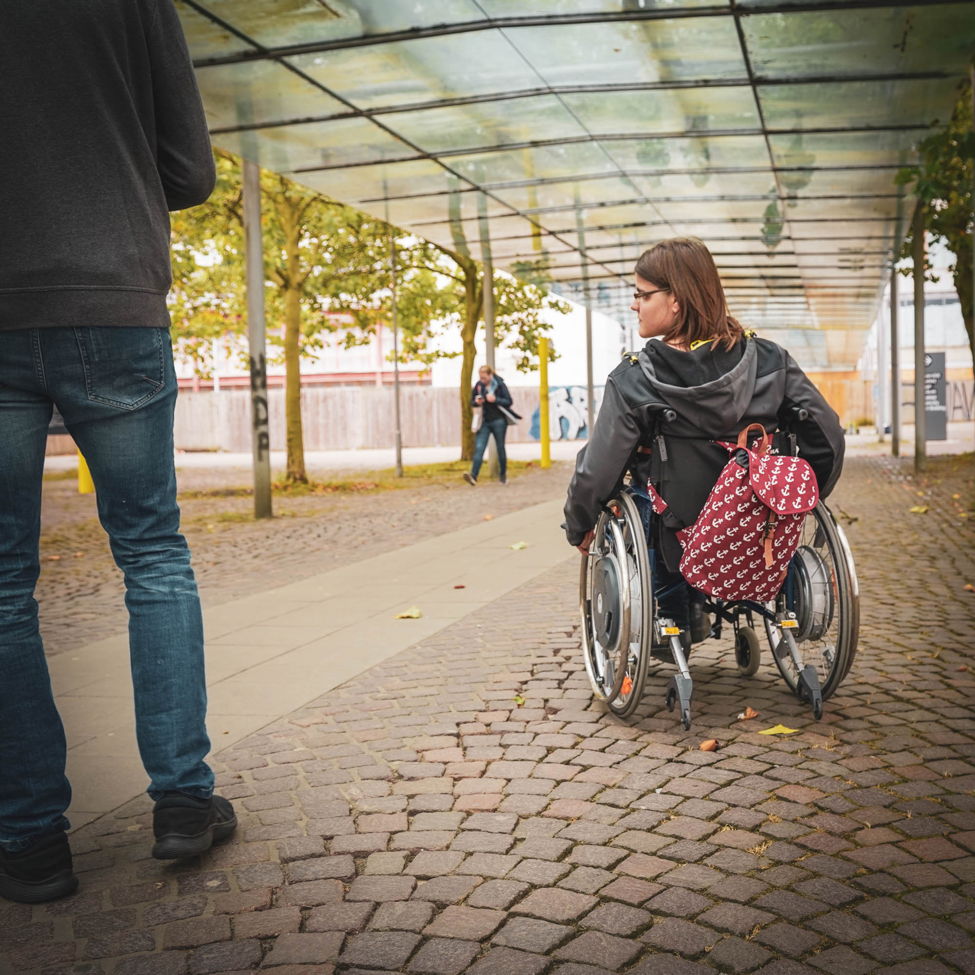 Wheelchair users in front of the university entrance