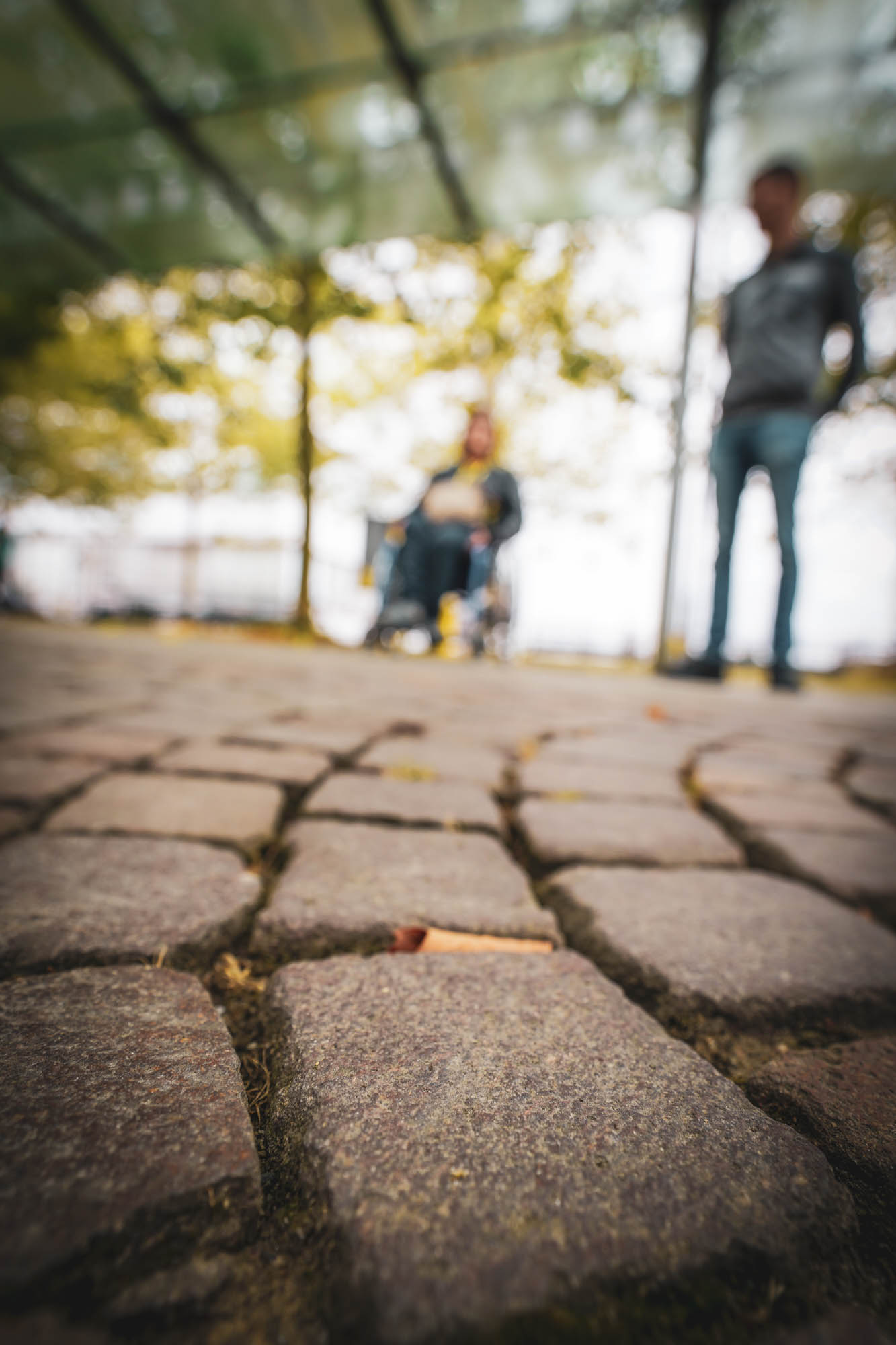 Two people out of focus on cobblestones