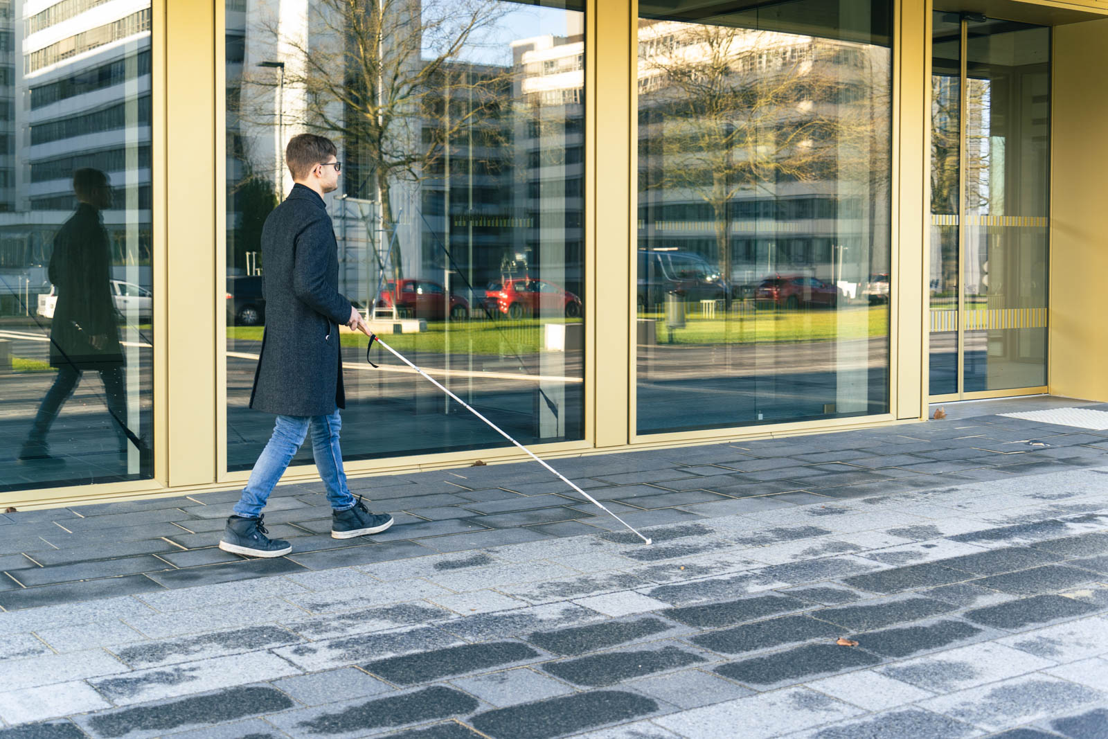 Blind student in front of the Lecture Hall building of Bielefeld University