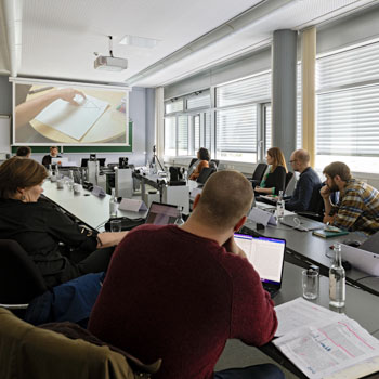 People sitting in the Long Table Room, discussing