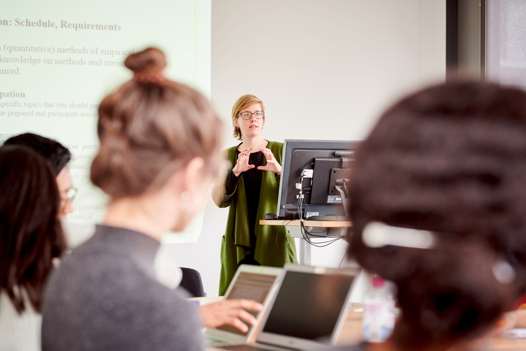 Foto einer Lehrperson, die vor Studierenden spricht