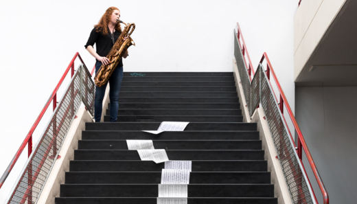Eine Musikerin spielt Saxophon auf der Treppe in Nichts in der Uni Bielefeld