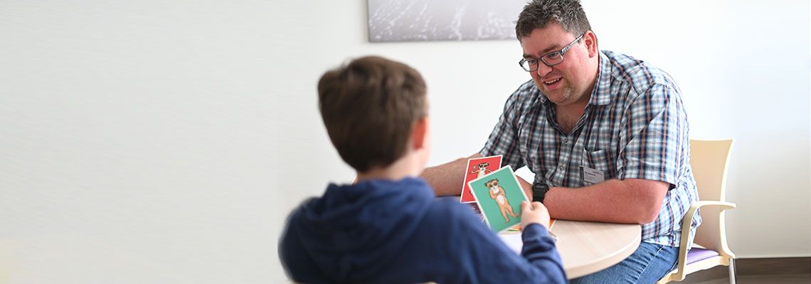 Therapiesituation in der Kinder- und Jugendpsychiatrie: Ein Therapeut im Gespräch mit einem jungen Patienten.