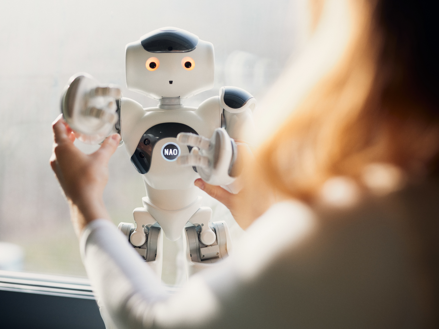 NAO-Robotter wird von einer Person bewegt 