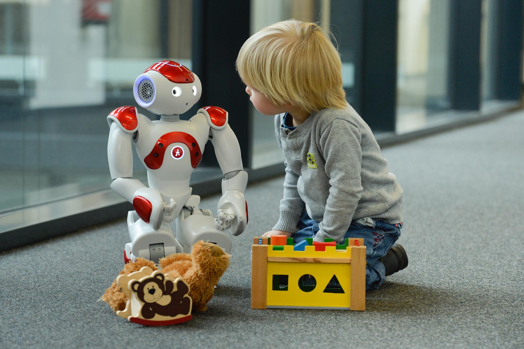 Kind und humanoider Roboter spielen zusammen