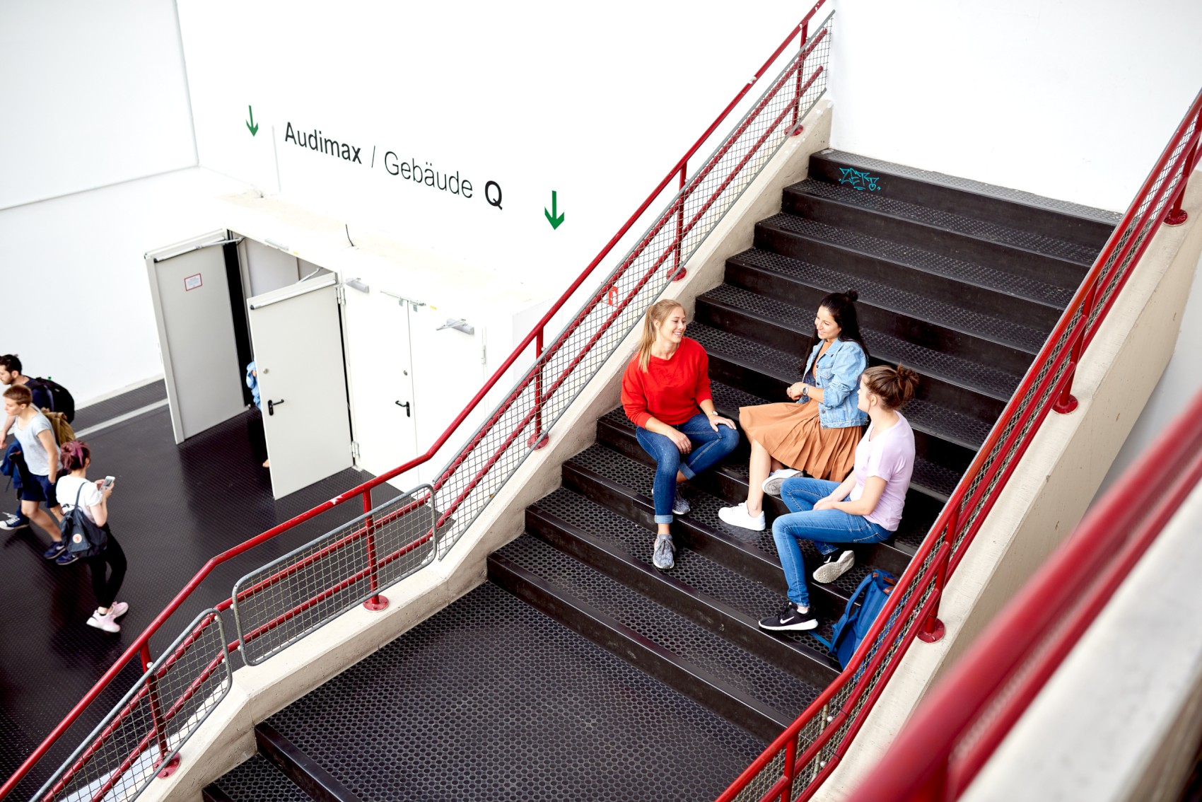 Studierende sitzen auf Treppe