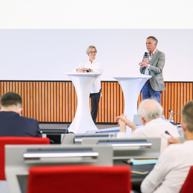 Prof'in Dr. Angelika Epple and Prof. Dr. Gerhard Sagerer stand at desks on a stage in front of an audience
