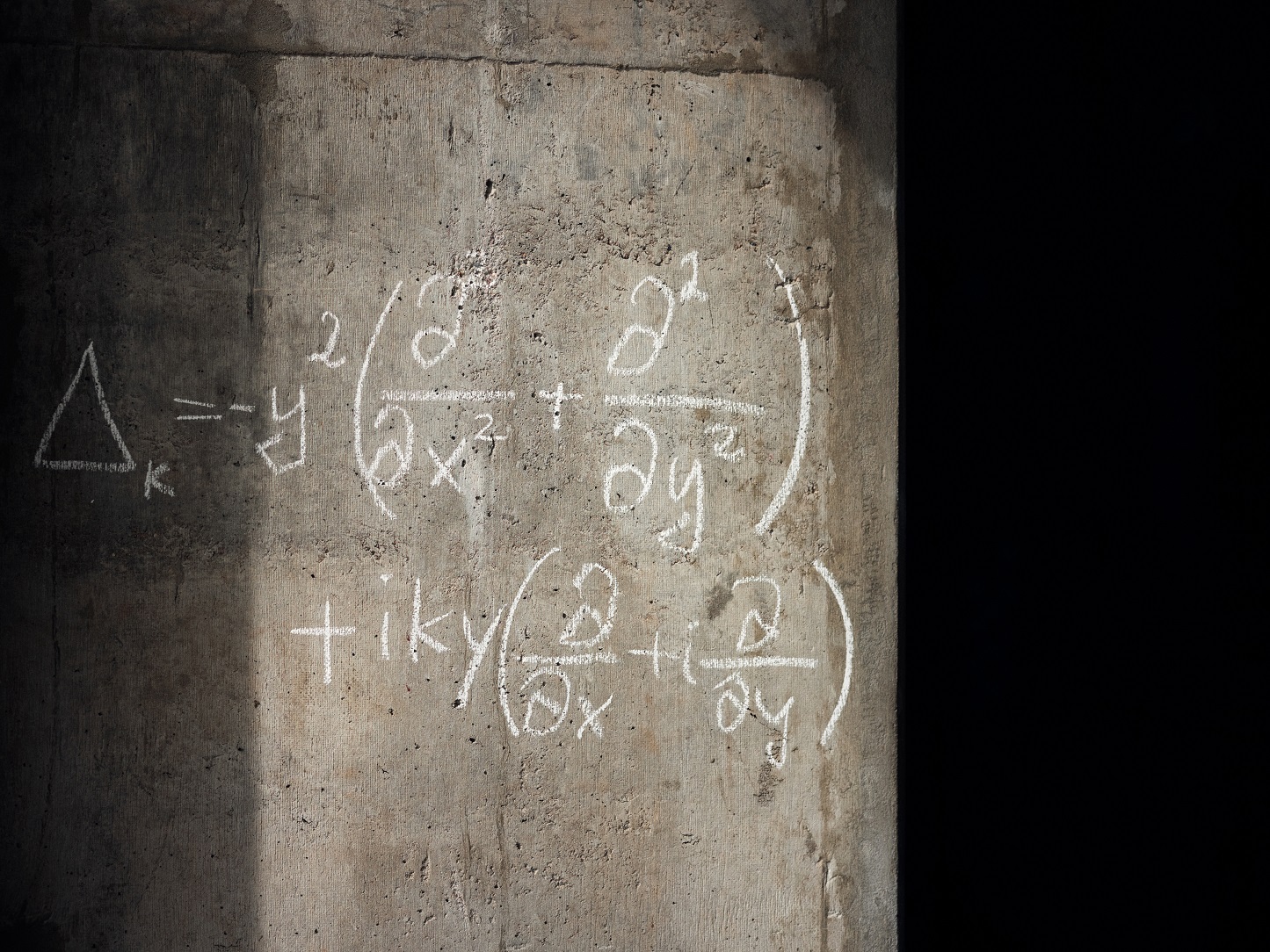 Mathematische Formeln mit Kreide auf Betonwand