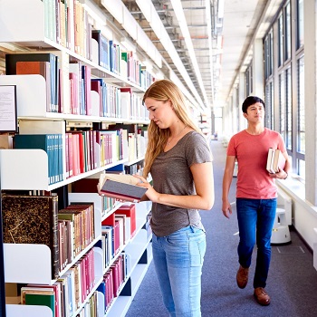A man and a woman in front of a library bookshelf