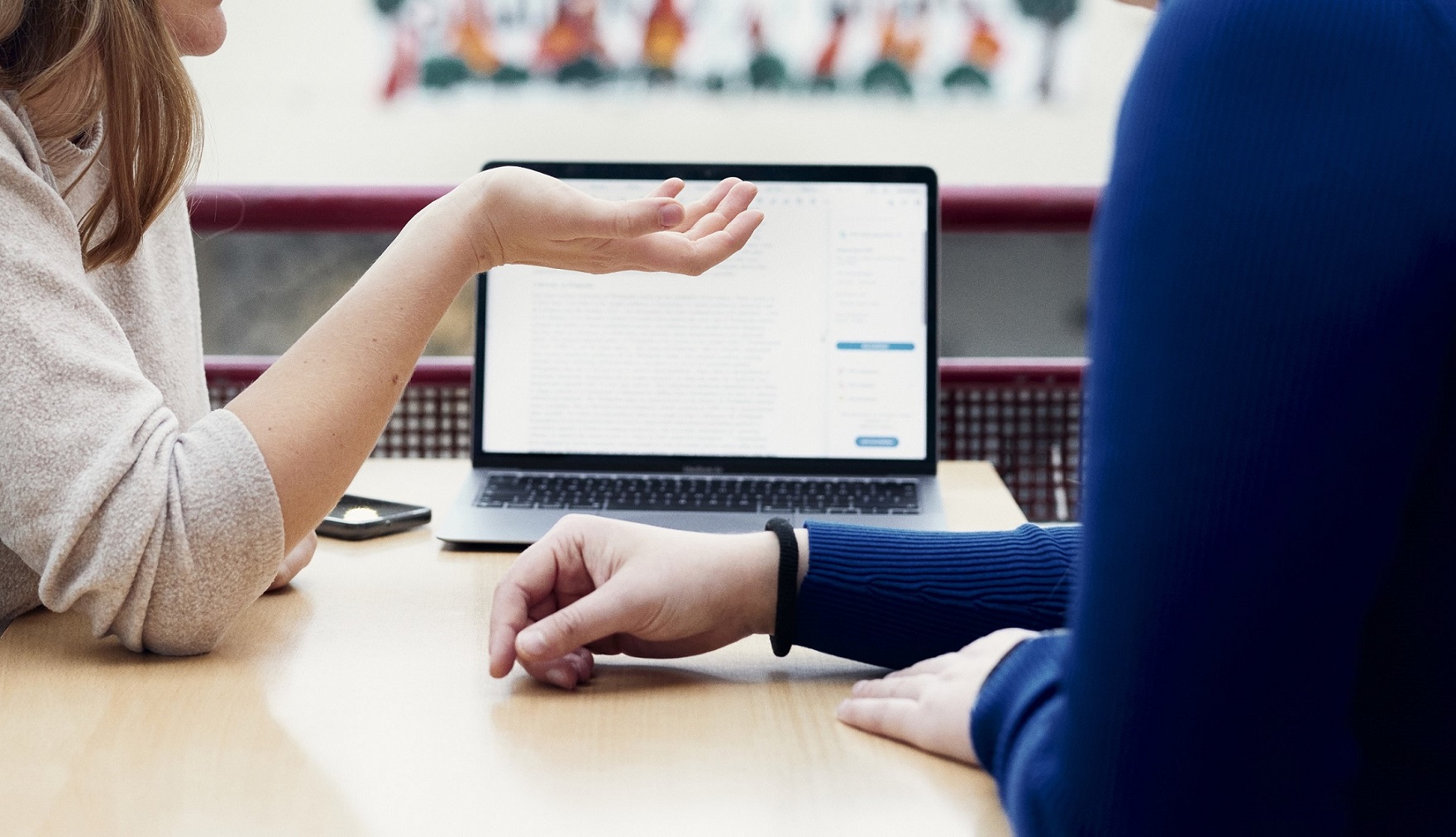 Hands gesturing in front of a laptop