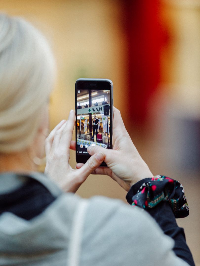 A woman takes a photo with a smartphone